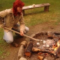 kapitán připravuje jablka plněná čokoládou v ohni