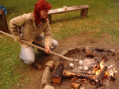 kapitán připravuje jablka plněná čokoládou v ohni
